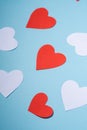 Red and white handmade paper hearts valentines on blue background