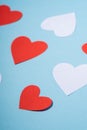 Red and white handmade paper hearts valentines on blue background