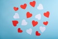 Red and white handmade paper hearts valentines on blue background