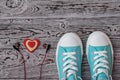 Red and white heart with headphones and turquoise sneakers n wooden floor. Sports style. Flat lay. Royalty Free Stock Photo