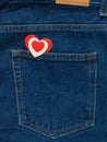 Red and white heart in the pocket of bright blue jeans