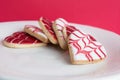 Red and White, heart shaped cookies on a plate with red background