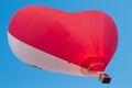 Red white heart shaped hot air balloon flying