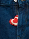 Red and white heart sticking out of the open fly blue jeans Royalty Free Stock Photo