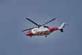 A red and white HM Coastguard Sikorsky S-92A helicopter in flight against a blue grey sky Royalty Free Stock Photo