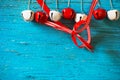 Red and white jingle bells and ribbn on blue Royalty Free Stock Photo