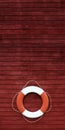 Red and white life buoy on the side of a wooden ship