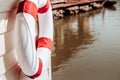 Red and white life buoy torus hanging on wooden wall of river fl Royalty Free Stock Photo