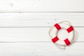 Red-white lifebuoy on white wooden board