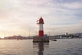 Red and white lighthouse at the entrance to the seaport Royalty Free Stock Photo