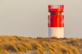 Red white lighthouse on Helgoland Duene island in evening sunlight Royalty Free Stock Photo