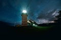 Red & White Lighthouse Light Beams at Night Royalty Free Stock Photo