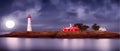 Red with white Lighthouse on sea shore at night in summer. Landscape view Royalty Free Stock Photo