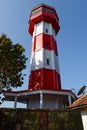 A Red and white lighthouse set against the sky