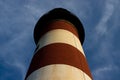 A red and white lighthouse stands tall against a blue sky Royalty Free Stock Photo