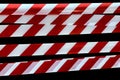 Red and white lines of barrier tape prohibit passage, tape on black isolate background