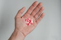 Red and white medicine capsules in the palm