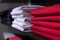 Red and white men clothing on shelf. T-shirt on rack for sale in shop. Autumn seasonal wear in department store Royalty Free Stock Photo