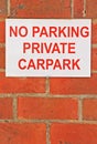 Red and white No Parking Private Carpark sign on brick wall Royalty Free Stock Photo