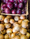 Yellow onions on display with red onions in a wicker basket Royalty Free Stock Photo