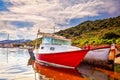 Red and white painted old boats washed upon the shore