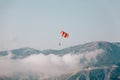 Red and white parachute on a clear blue sunny day with clouds Royalty Free Stock Photo