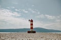 The red-white pendulum stands against the backdrop of the mountains, the sky. Royalty Free Stock Photo