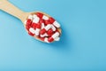 Red and white pill capsules on a blue background. Royalty Free Stock Photo