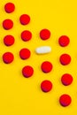 Red and white pills and yellow background