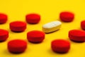 Red and white pills and yellow background