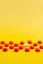 Red and white pills and yellow background