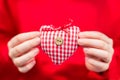 Red-white plaid textile heart in hands