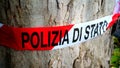 red and white plastic ribbon with State Police written in Italian, tied to a tree to delimit a traffic