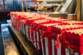 red and white popcorn bags lined up with machine in background Royalty Free Stock Photo