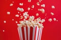 Red and White Popcorn Tub with Popcorn Exploding. Royalty Free Stock Photo