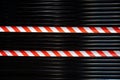 red and white prohibition tape on a black. metal roleta. closed during a pandemic in the world. crime scene Royalty Free Stock Photo