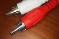 Red and white RCA plugs on wooden table. Macro photography Royalty Free Stock Photo