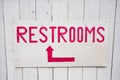 Red and White Restrooms Sign with Arrow