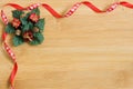 Red and white ribbon on light wood background with Christmas wreath decoration Royalty Free Stock Photo