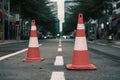 Red and white road cones on footpath, safety concept photo