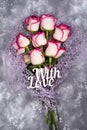 Red white rose flower bouquet and lettering With Love on stone table. Royalty Free Stock Photo