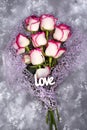 Red white rose flower bouquet and lettering Love on stone table. Royalty Free Stock Photo