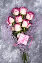 Red white rose flower bouquet with pink gift box on stone table. Royalty Free Stock Photo