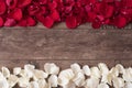 Red and white rose petals on the wooden background. Rose Petals Border on a wooden table. Top view, copy space. Floral frame. Royalty Free Stock Photo