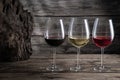 Red, white and rose wine in wine glasses on dark wood background. Beverage and wine concept Royalty Free Stock Photo