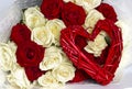 Red and white roses in a bouquet and a red heart from a vine. Valentine`s day background Royalty Free Stock Photo