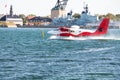 Red and white seaplane taking off in Copenhagen city