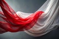 Red and white sheer fabric flowing and undulating against a dark gray backdrop cloth textile Royalty Free Stock Photo