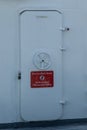 Red and white sign on a metallic door - controlled area, authorised personnel only