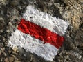 Red and white sign painted on rock marking hiking trail or the Swiss mountain trail marking Royalty Free Stock Photo